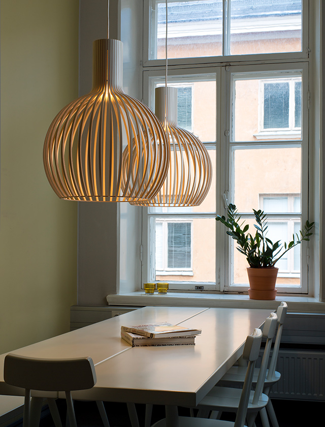 Weiße Secto Design Octo Small 4241 Pendelleuchten aus Holz über einem Esstisch in skandinavischem Interieur