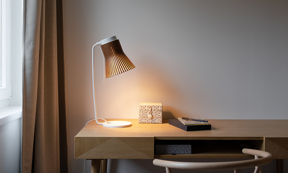 Die Secto Design Petite 4620 Tischleuchte kombiniert finnisches Handwerk mit klarer Formensprache. Der Schirm aus Birkenholz lenkt das Licht sanft und erzeugt eine warme, natürliche Atmosphäre – ideal für Schreibtisch, Nachttisch oder Leseecke.