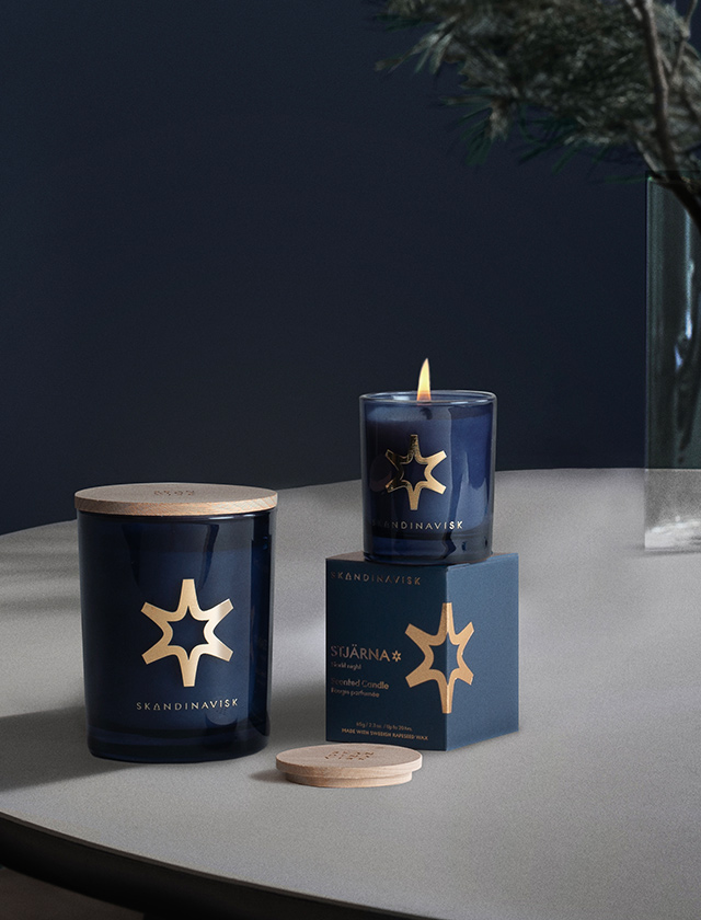 Skandinavisk STJÄRNA Duftkerzen 65 g und 200 g der Gold Edition in dunkelblauem Glas mit goldfarbenem Sternmotiv
