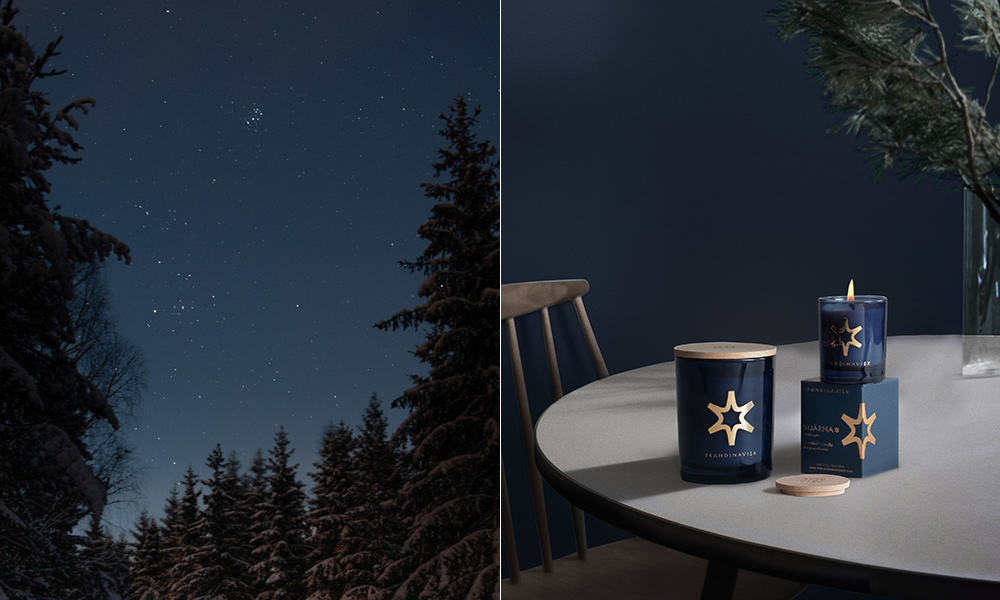 Skandinavisk STJÄRNA Duftwelt mit verschneitem Wald unter klarem Sternenhimmel und dunkelblauen STJÄRNA Duftkerzen in skandinavischem Ambiente