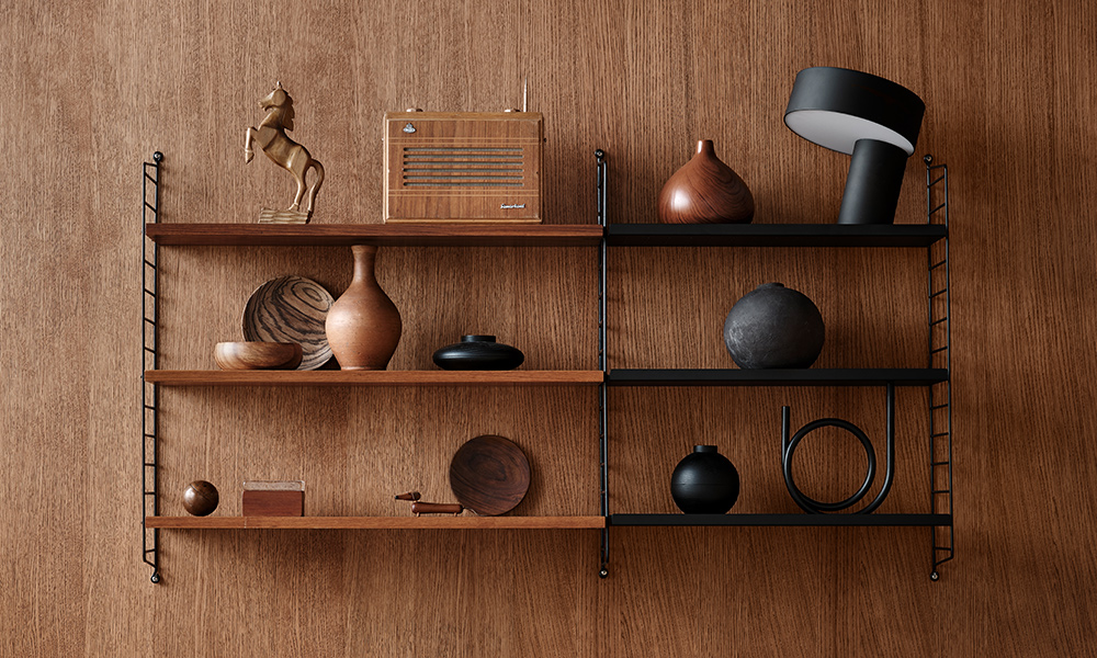 Das String-System von String Furniture kombiniert elegantes Walnussfurnier mit schwarzen Metallfachböden & Wandleitern in einem Wandregal mit seiner Tiefe von 20 cm.