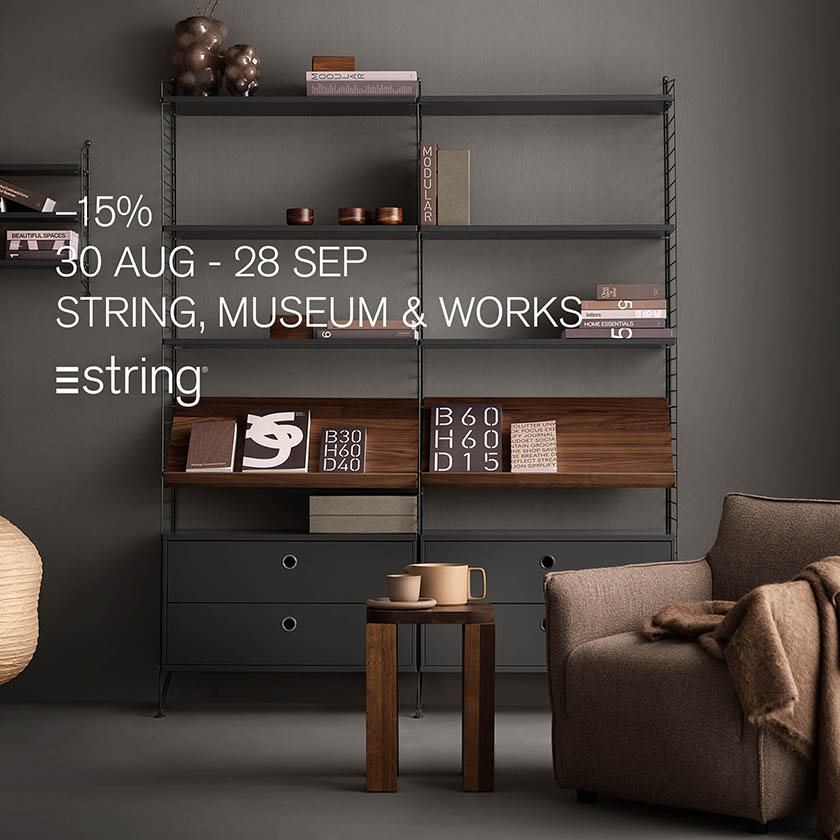 Elegantes String Regalsystem in dunklem skandinavischem Design mit minimalistischer Deko und gemütlichem Sessel – Herbstaktion mit 15 % Rabatt auf String, Museum & Works Möbel vom 30. August bis 28. September.