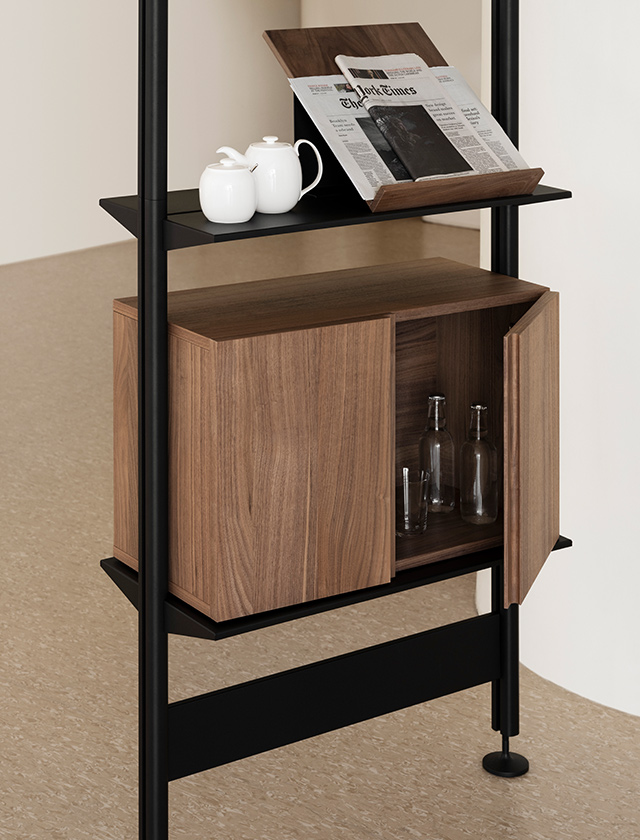 Pira Regal System ist ein elegantes und vielseitiges Möbelstück, das sowohl als Stauraum als auch als Raumteiler genutzt werden kann. Mit einer Breite von 70 cm kombiniert es hochwertige Materialien wie Walnuss, Schwarz und Grau, wodurch es eine warme und gleichzeitig moderne Ausstrahlung erhält.