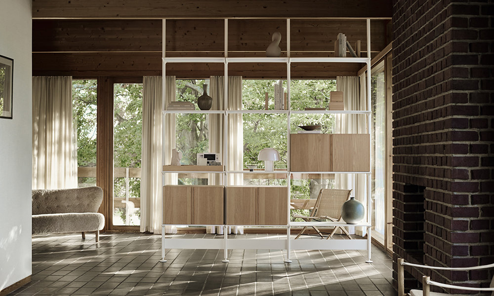 Das G2 Regal System von String Furniture als Raumteiler eingesetzt. Die weißen Segmente sind vom Boden bis zur Decke gespannt und haben je Fachboden eine Traglast von 50 KG. Die Segmente sind in einer 70 cm und 90 cm Breite erhältlich.